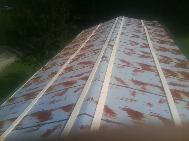 Rusted metal roof panels with new wood purlins before replacement — Storm Damage Roof Repair in Pearl City by Roofing Brothers
