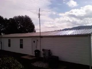 New metal roof on a single wide mobile home with a TV antenna in Pearl City