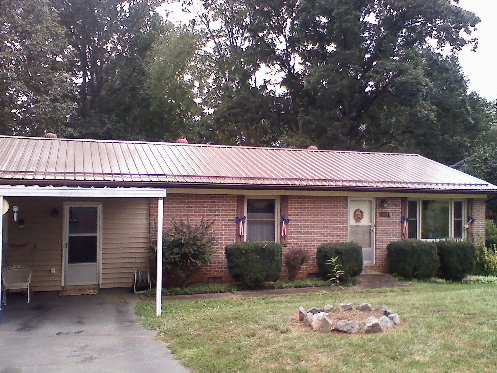 Bronze metal roof and carport on a brick ranch home — Roof Repair work by our crew in Pearl City