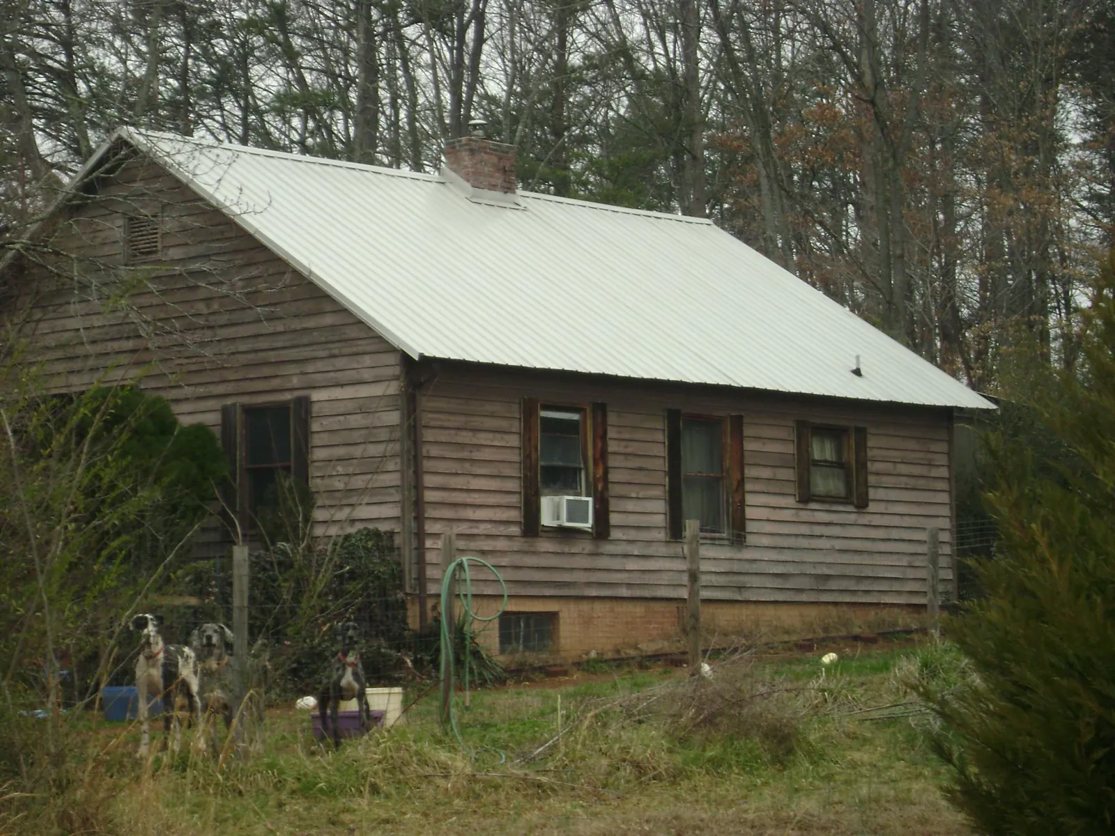 White metal roof on an old wood sided farmhouse, from a Asphalt Shingle Roof Repair job in Pearl City